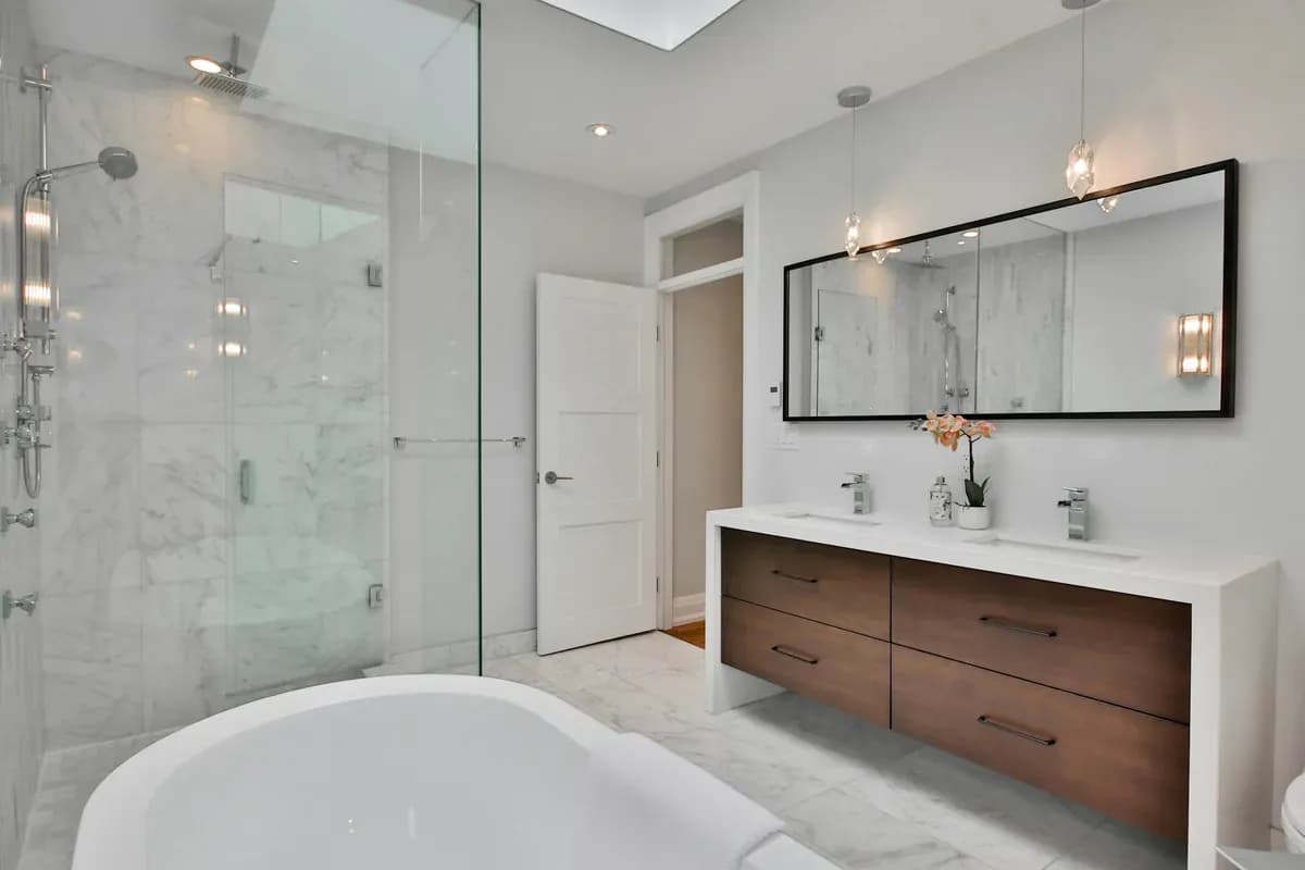 İşıqlı hamam: mərmər divarlar, şüşə duş kabinəsi və taxta şkaf